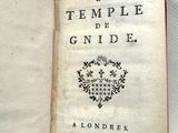 un livre ouvert avec une écriture dessus, posé sur une table