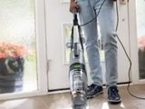 un homme qui passe l'aspirateur pour nettoyer le sol