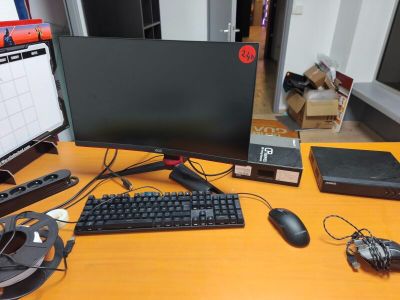 a computer monitor, keyboard, mouse, and mouse pad on a desk