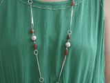 une femme vêtue d'une robe verte et portant un collier de perles
