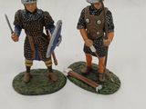 two figurines of men dressed in medieval clothing and holding swords