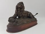 bronze statue of a lion on a wooden base with a white background