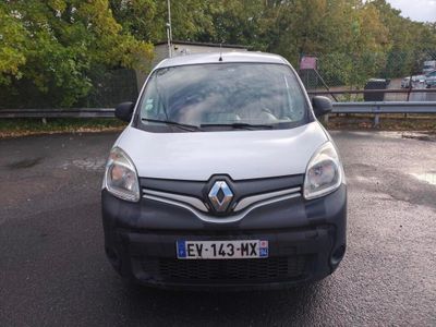 une camionnette blanche garée sur un parking avec des arbres en arrière-plan