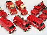 beaucoup de petits camions de pompiers rouges en plastique posés sur une table