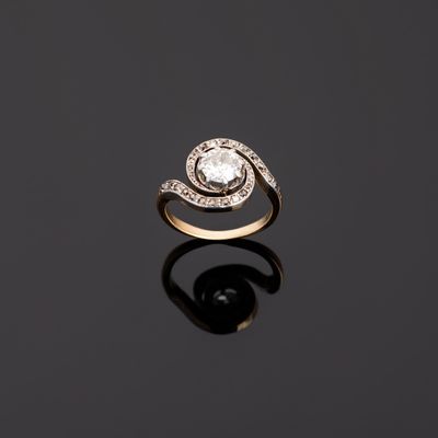 a diamond and gold ring on a black surface
