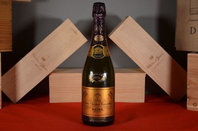 une bouteille de champagne posée sur une table, à côté de caisses en bois