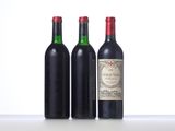 three bottles of wine are lined up on a table