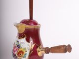 a red tea pot with a wooden handle on a white background