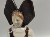 a figurine of a woman with a large bow on her head