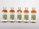 quatre bouteilles d'alcool posées les unes à côté des autres sur une surface blanche