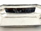 an antique silver plate on a white background with a reflection in the center