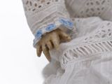 a close up of a doll wearing a white dress