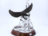une image représentant une statue d'aigle planant au-dessus d'une montagne