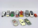 Plusieurs petites voitures et camions sont alignés sur une surface blanche