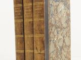 two old books sitting on top of each other on a white surface