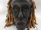 an image of a wooden mask with dreadlocks on a white background