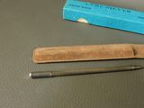 a pen and a pencil on a table next to a blue box