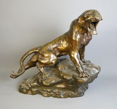 bronze statue of a lion on a rock on a white background