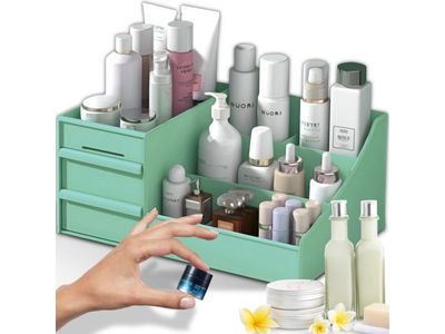 la main d'une femme tenant un flacon de lotion à côté d'une boîte de produits de beauté