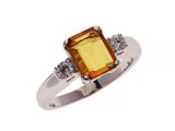 un gros plan d'une bague sertie d'une pierre orange et de diamants