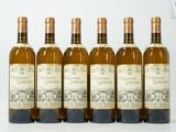 six bouteilles de vin sont alignées sur une table