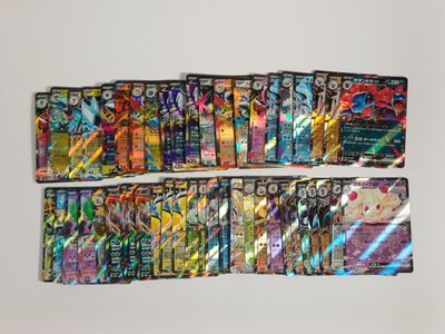 Plusieurs cartes Pokémon différentes sont alignées sur une surface blanche