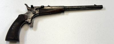 un vieux pistolet posé sur une surface blanche