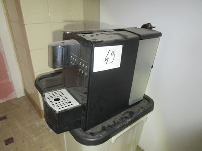 une machine à café posée sur une poubelle