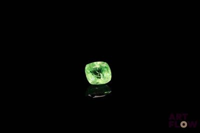 a close up of a green diamond on a black surface