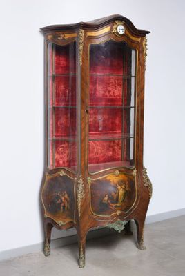 an antique display cabinet with a red velvet covering