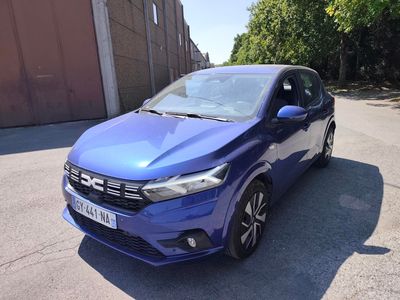a blue car parked on the side of the road in front of a building