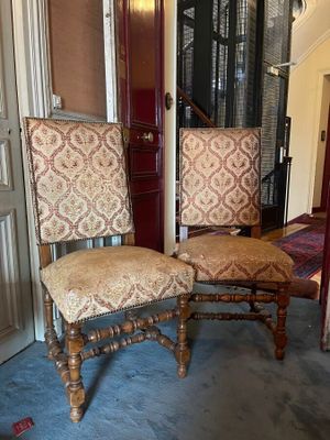 two chairs that are sitting next to each other in a room