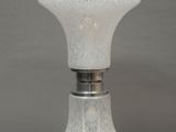a white glass lamp that is on a table