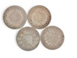 six different british coins are arranged in a row on a white surface