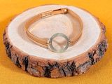 un bracelet orné d'un cercle, posé sur une souche d'arbre