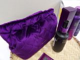 a purple bag sitting on top of a table next to a bottle of lotion