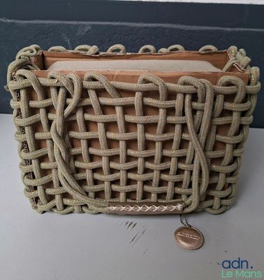 un sac à main en tissu contenant une pièce de monnaie, posé sur une table