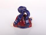 a small figurine of a man sitting on top of a red and blue object