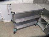 a stainless steel shelf with three shelves on it in a room