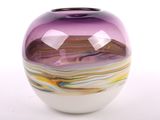 un vase en verre violet avec un socle blanc, posé sur une table