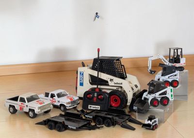 a toy truck and a truck with a crane on the back of it