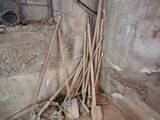 un tas de balais et de pelles dans un coin de la pièce