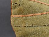 a close up of a green hat with orange stitching on it