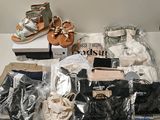 Plusieurs paires de sandales sont posées sur une table, à côté d'une paire de chaussures.