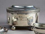 a silver plate with a bowl on it and a bowl on the ground