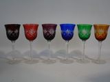 six verres à vin sont alignés sur une surface blanche