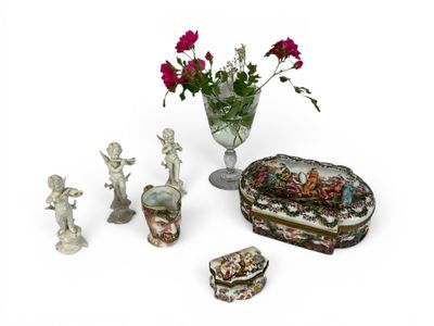 a vase with flowers and figurines on a table
