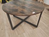 une table basse avec un plateau en bois posée sur un parquet en bois massif