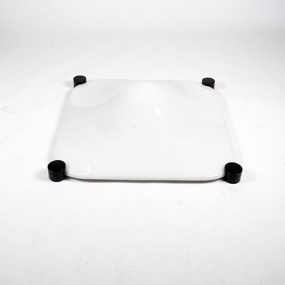 white square plate with black handles on a white surface
