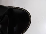 a close up of a pair of black shoes on a white surface